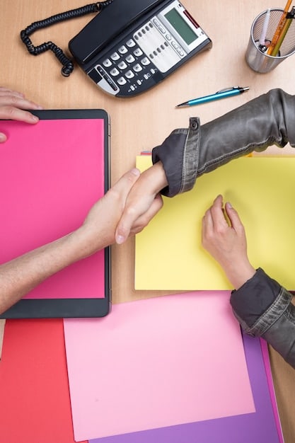 A person confidently shaking hands with an insurance adjuster in a bright, modern office. Papers are on a table, symbolizing a successful negotiation and agreement.