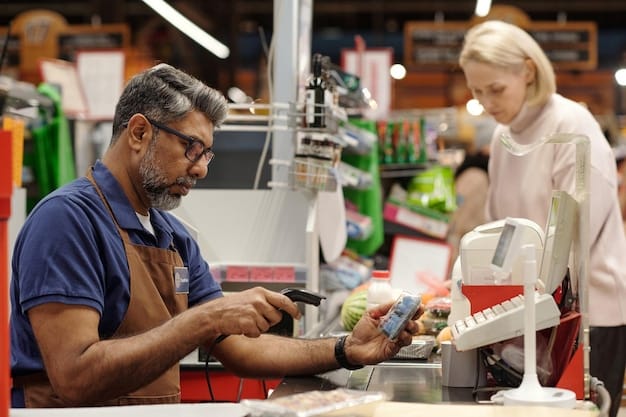 A cashier processing a price match at a grocery store checkout. The cashier is smiling and interacting positively with the customer, who is holding up a smartphone displaying a competitor's lower price.