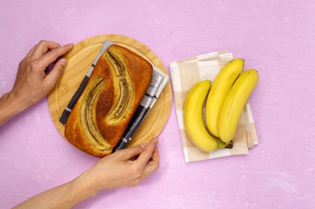 A close-up of hands peeling slightly browned bananas next to a bowl of ingredients for banana bread, showing how to utilize overripe fruit.