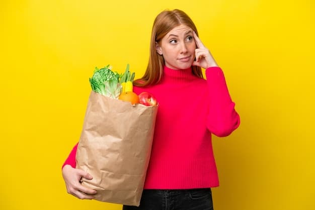 A person holding a reusable grocery bag, looking at prices in a supermarket aisle, with a thoughtful expression, representing savvy shopping and budgeting.