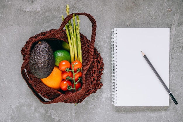 A detailed close-up of a well-organized grocery list on a notepad, with a pen resting on it, signifying careful planning and strategic shopping. The background is slightly blurred with grocery store aisles.