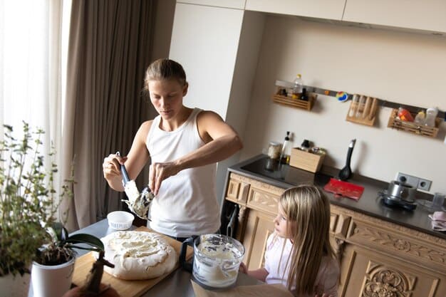 A family happily cooking together in a clean, modern kitchen. One parent is stirring a pot, another is chopping vegetables, and a child is mixing ingredients, highlighting togetherness and home-cooked meals.