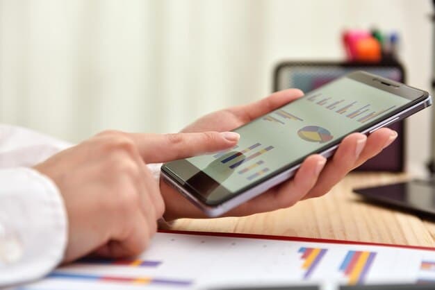 A person's hands holding a mobile phone displaying a credit score chart, with various financial app icons blurred in the background, representing personal control over credit monitoring.