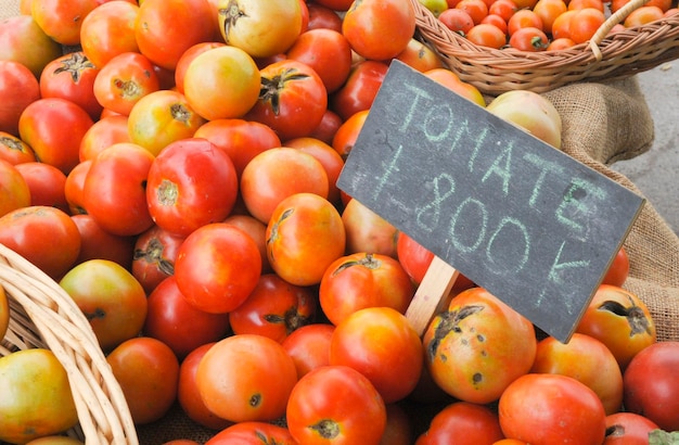 A close-up shot of organically grown seasonal fruits and vegetables at a local farmers market. Baskets overflow with colorful items, with a focus on the vibrant textures and natural colors, demonstrating the freshness of The Ultimate Guide to Seasonal Produce: Save Money by Buying What's in Season.